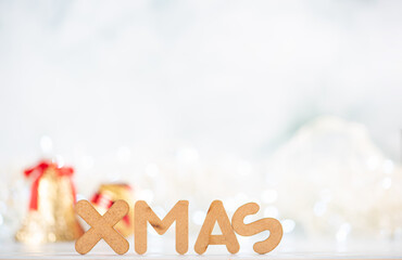 Xmas, word Xmas written with wooden letters and Christmas lights, selective focus.