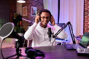 Popular vlogger recording internet show with professional camera and sound equipment in studio....