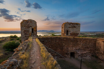 Mourao castle towers and wall at sunset with alqueva dam in Alentejo, Portugal