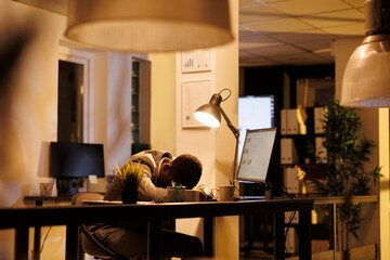 Tired drained businessman sleeping on desk in workspace, workaholic employee falling asleep after...
