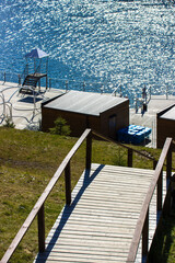 Wooden steps of the stairs leading to the embankment at the river, sea, lake. Vertical photo of...