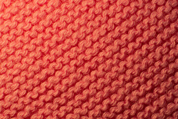 Texture of the fabric of a red sweater. Macro view of the pattern in diagonal