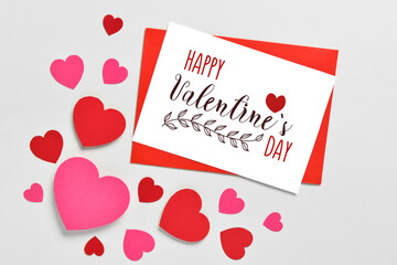 Greeting cards for Valentine's Day and paper hearts on light background