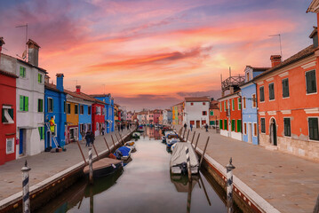Explore the charming canals of Burano, Venice, Italy with this picturesque scene showcasing the...