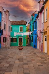 Fototapeta na wymiar Discover the charming, colorful streets of Burano, Venice. This photo captures the traditional Venetian architecture and vibrant hues of the buildings, creating a peaceful and serene atmosphere.