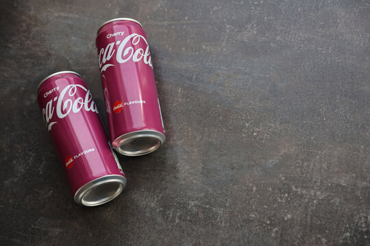 KYIV, UKRAINE - 4 MAY, 2023: Coca cola soft drinks brand tin cans with cherry flavour close up