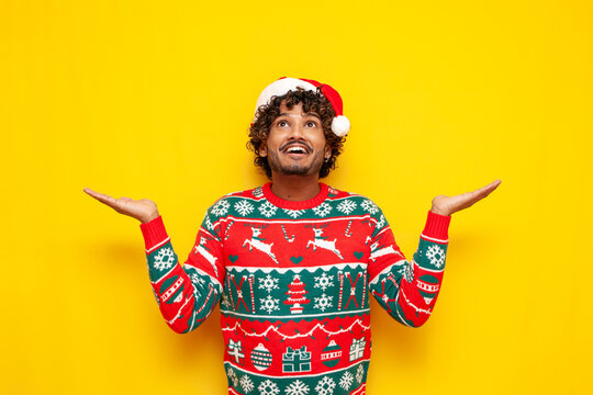 young indian man in new year clothes catches copy space and dreams on yellow isolated background