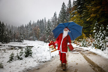 Santa Claus Delivering a Gift in Rural Remote Location on Countryside in Extreme Winter Weather - Outdoors Snowing Hard Over Forest