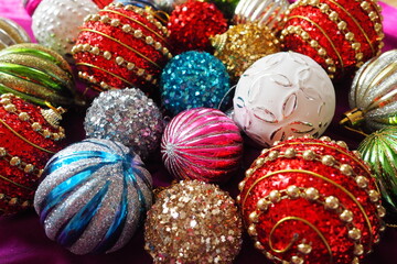 Fototapeta na wymiar Colourful glass shiny balls. New Year's Christmas decoration. Festive design. Red, blue, golden, white, green striped balls. Christmas and New years eve Background. Close up of Christmas ornaments.