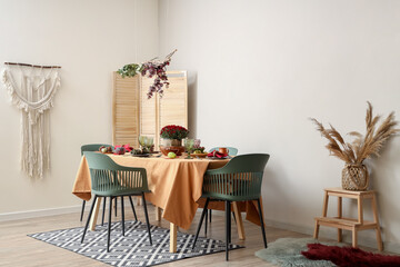 Beautiful autumn table setting with bouquet of flowers and pumpkins in modern dining room