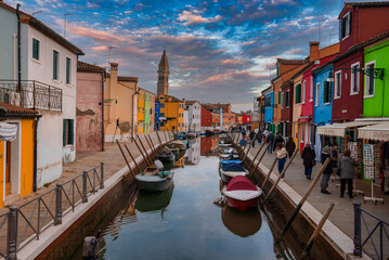Fototapeta na wymiar Explore the charming canals of Burano, Italy with this vibrant and picturesque scene. Colorful buildings, boats, and gondolas create a stunning reflection in the water.