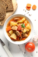 Bowl with delicious beef stew and bread on white background