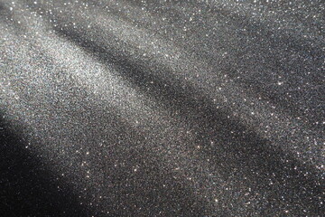 Oblique rays of light on a black surface. Bokeh, dust particles, reflection and magical glow....