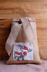 Christmas gift in burlap bag with Rudolph the red-nosed Reindeer