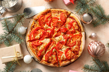 Wooden board with delicious pizza and Christmas decor on beige background