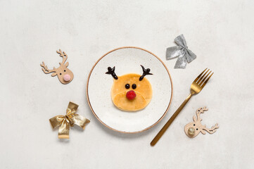 Plate with pancake in shape of reindeer on white background. Christmas celebration