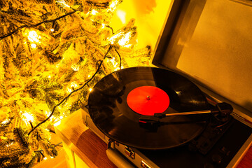 Vintage record player on cabinet with Christmas decor in living room at evening
