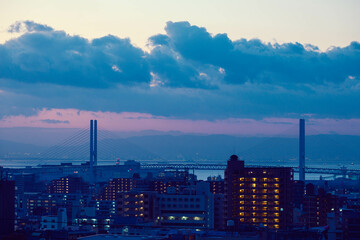 夜明け前の都市。神戸の高台から神戸・大阪のビル群と大阪湾をのぞむ
