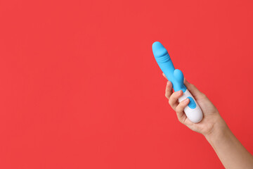 Female hand with vibrator on red background