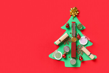 Christmas tree made of makeup cosmetics and decor on red background