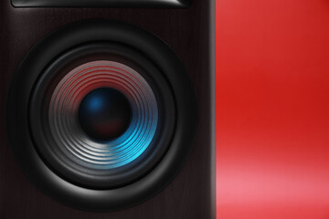 Fototapeta na wymiar One wooden sound speaker on red background, closeup. Space for text