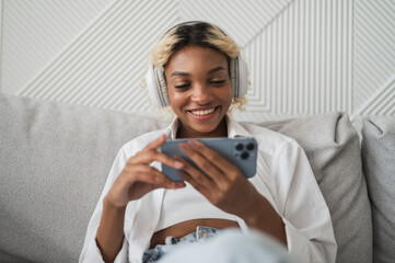 Closeup portrait of dark skinned woman watching video on streaming service or social media on her smartphone.female student watching lectures,educational materials etc