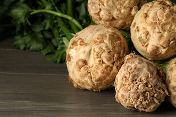 Fresh raw celery roots on wooden table, closeup. Space for text