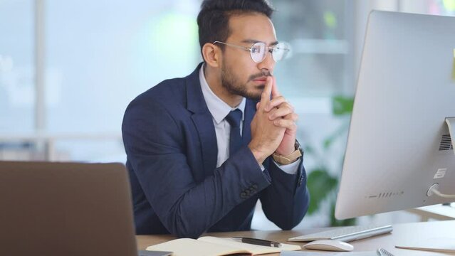 Business man analyzing a project strategy on a computer screen while working in an office. Serious and focused corporate professional thinking of solutions while deciding ideas, choices and plans