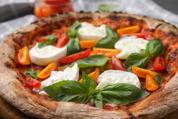 Delicious pizza with burrata cheese, tomatoes and basil on table, closeup