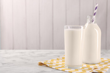 Glassware with tasty milk on white marble table, space for text