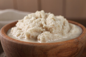 Spicy horseradish sauce in bowl against blurred background, closeup