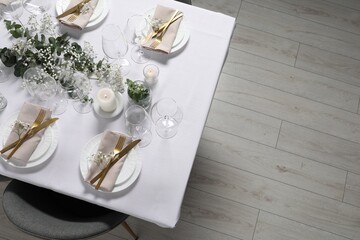 Beautiful table setting with floral decor, above view. Space for text