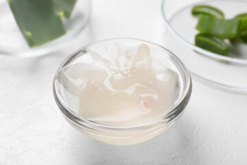 Aloe vera gel and slices of plant on white background, closeup