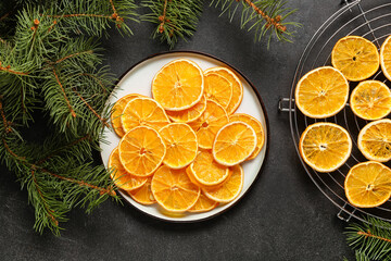 Plate and stand with dried orange slices on black background