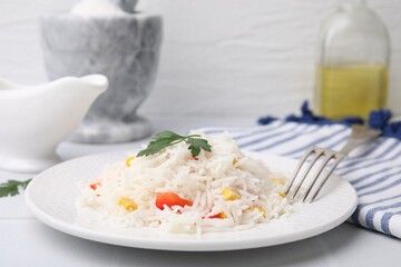 Delicious rice with vegetables and parsley served on table, closeup