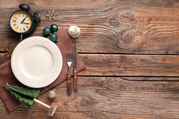 Beautiful table setting for Christmas dinner with alarm clock and decorations on wooden background