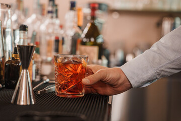 Bartender pouring vibrant red drink into martini glass, showcasing elegance and precision of...