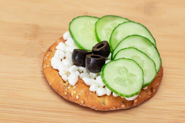 Crispy Cracker Sandwich with Fresh Cucumber, Cottage Cheese and Olives on Cutting Board. Diet Food. Easy Breakfast. Quick and Healthy Sandwiches. Crispbread with Tasty Filling. Healthy Dietary Snack