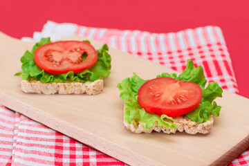 Rice Cake Sandwiches with Tomato and Lettuce on Wooden Cutting Board. Easy Breakfast. Diet Food. Quick and Healthy Sandwiches. Crispbread with Tasty Filling. Healthy Dietary Snack