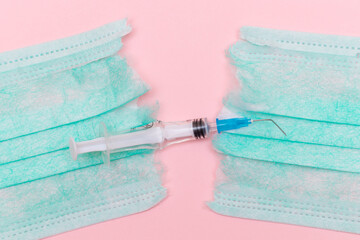 Anti Vaccine Movement and Anti Mask Concept - Broken Medical Syringe and Green Torn Medical Face...