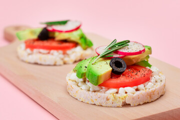 Rice Cake Sandwiches with Avocado, Tomato, Cottage Cheese, Olives and Radish on Wooden Cutting...