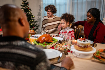 Multi-ethnic big family celebrating Christmas party together in house.