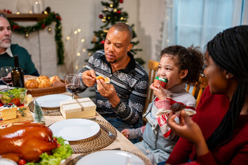 African American family celebrating Christmas party together in house.