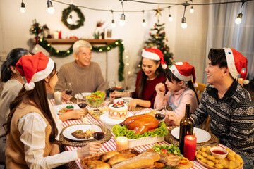Asian lovely family celebrating Christmas party together in house.