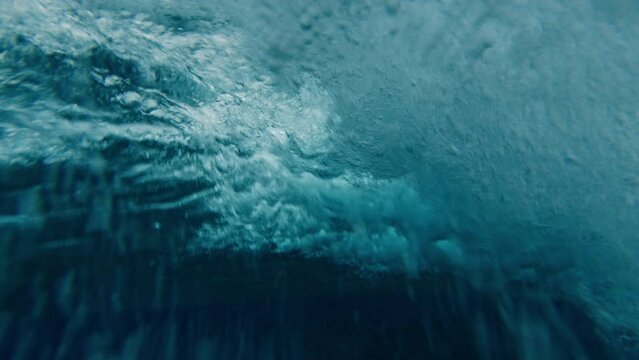 Surfer rides the ocean wave during overcast rainy day