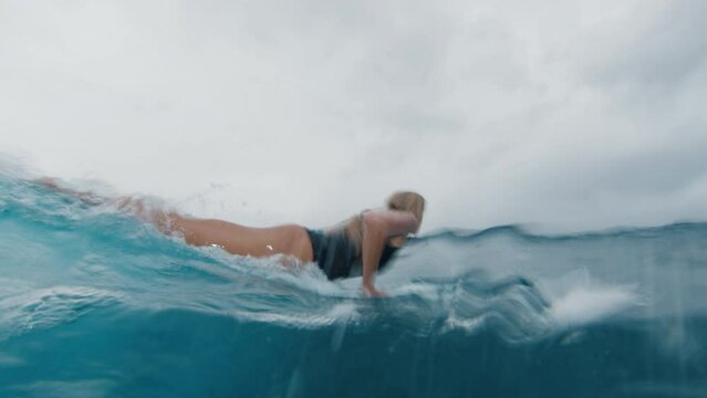 Woman surfer paddle in the ocean