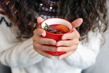 Young African-American woman with cup of hot mulled wine, closeup