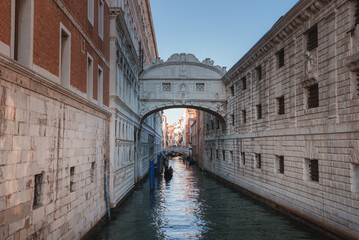 Tranquil view of a narrow canal in Venice, Italy. Serene atmosphere with no visible boats. Unique architectural buildings line the canal, capturing the essence of Venice.
