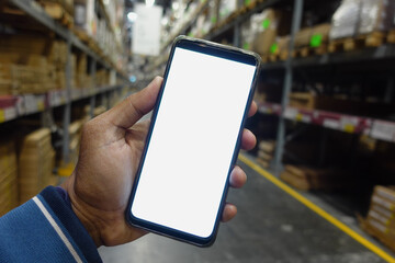 business owner holding phone mock up in warehouse.