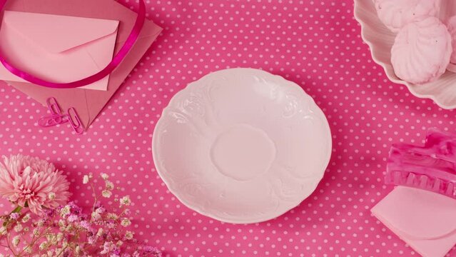 Pink background with cup of milk or tea, birthday barbie style table for tea ceremony with cakes and desserts, girl fashion food background, top view.